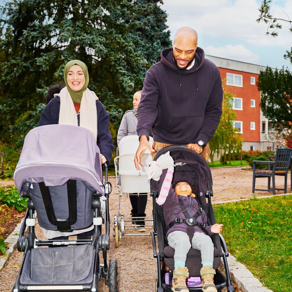 vuxna på promenad med barnvagnar